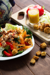 Ensalada Verde con pollo croutones y aderezo en mesa de madera