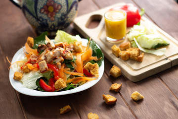 Ensalada Verde con pollo croutones y aderezo en mesa de madera