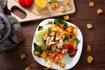 Ensalada Verde con pollo croutones y aderezo en mesa de madera