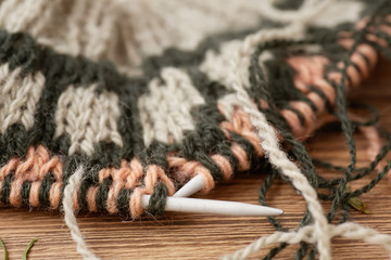 knitting warm clothes with knitting needles. Jacquard pattern, close-up