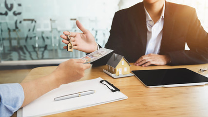 Cropped shot  of real estate agent giving house key to his customer