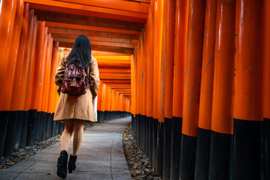 One Asian woman traveller with backpack walking and sightseeing at famous destination Fushimi Inari Shrine in Kyoto, Japan. Japan tourism, nature life, or landscape most visited tourist.