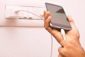 Maski, India 18,January 2020 - Hand holding smartphone and connecting USB type C charger cable to mobile for charging.