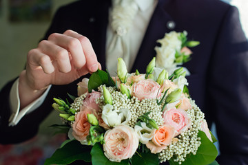 Obraz na płótnie Canvas wedding bouquet in the hands of the groom