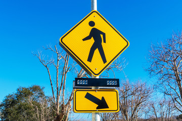 Pedestrian crossing sign with flashing lights. Crosswalk beacon provides advance notice of...