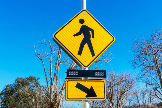 Pedestrian crossing sign with flashing lights. Crosswalk beacon provides advance notice of pedestrian activity for drivers