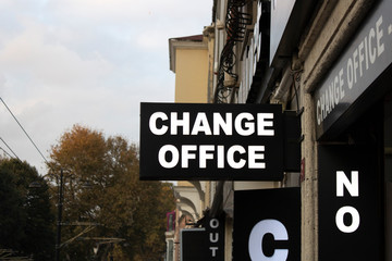 Signpost belonging to the exchange office. Close-up. White text on black signboard.