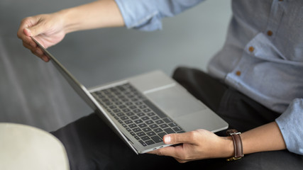 Close up view of businessman using laptop on his lap