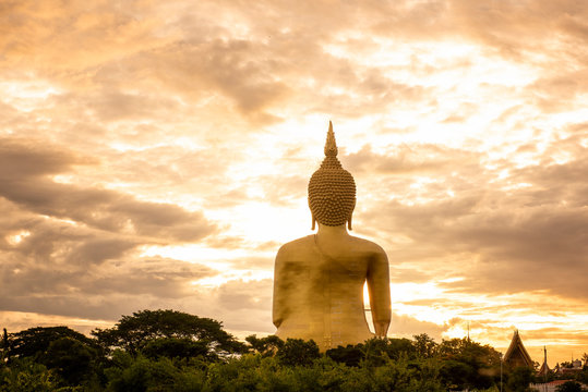 Makha Bucha Day, Visakha Bucha, a large shadow Buddha statue behind a golden sunset in Thailand