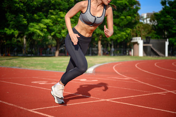 Fototapeta premium strong and healthy body of young woman sproty in the way of start practice running in sport stadium