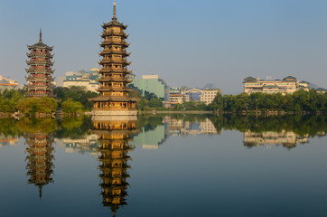 Sun and Moon Pagodas reflected in Shanhu or Fir Lake in early morning in Guilin China