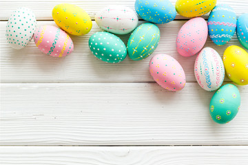 Colorful Easter eggs frame on white wooden background top-down copy space
