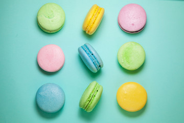 Different colorful macaroons on blue background. Square form