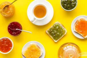 Tea party with jam. Toast, teapot, cup on yellow background