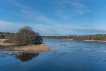 Winter landscape over a partly frozen lake Mälaren in the district of Bromma in Stockholm a cold sunny day.