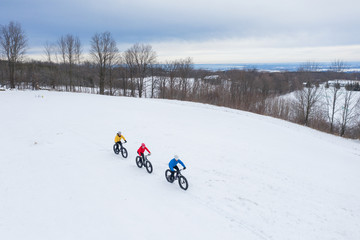 Aerial drone photo of a group of friends riding their fat bike in the snow in Ontario, Canada