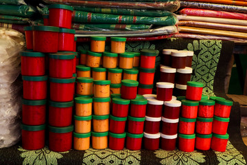 Cute little plastic jars with lids having colorful turmeric powder