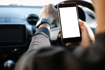 Cropped shot view The driver uses the phone while driving. Modern smart phone with round edges. Isolated screen for mockup. Car navigation display in background. 