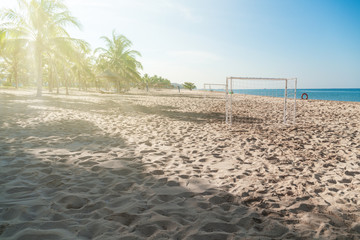 Soccer goal post on the beach with sand and blue sky