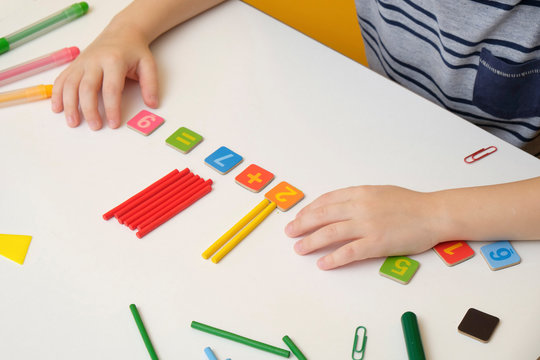 Little boy child preparing for elementary school doing simple math exercises. Close up