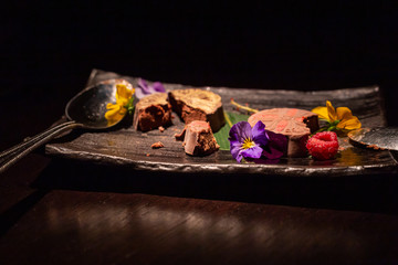 Indulgent, stylish chocolate based dessert decorated with colourful flowers. With copy space