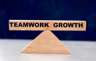 concept of word balance growth and teamwork on wooden scales