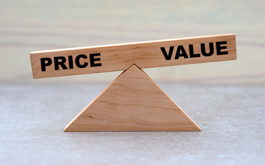 concept words price and value on wooden scales on a light background