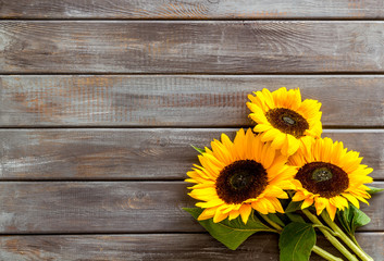 Bouquet of sunflowers on dark wooden background top-down copy space