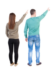 Fototapeta premium Back view of couple couple in sweater pointing.
