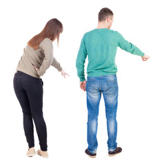 Back view of couple couple in sweater pointing.