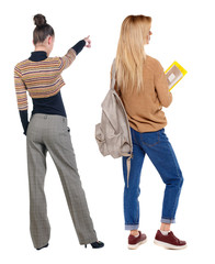 Back view of two pointing young girl in sweater.