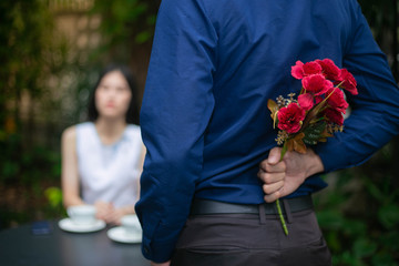 Man holding pink bouquet of roses on back, Surprise special time.