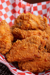 A closeup of a basket of Korean fried chicken in a restaurant or kitchen setting.