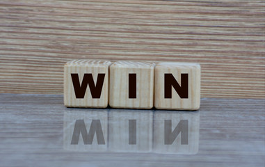 concept word win on cubes with a mirror image on a grey shiny background
