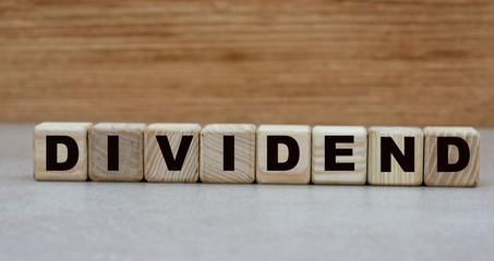 Obraz na płótnie Canvas concept word dividend on cubes on a wooden background