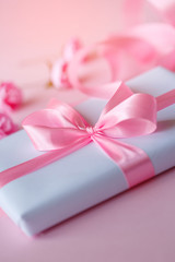 Decorative white gift box with pink bow and long beautiful ribbon.