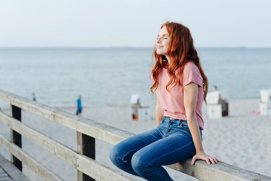 Casual trendy young woman relaxing on a pier