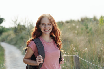 Happy healthy young woman backpacking