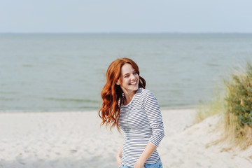 Smiling happy young woman enjoying the coast