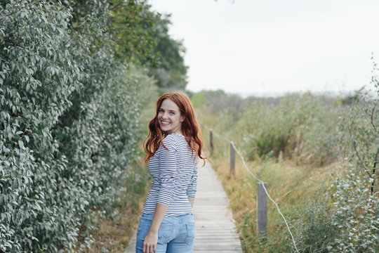 Pretty young redhead woman turning to the camera
