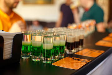 Alcoholic drink. Green alcoholic cocktail at the bar. Shot.