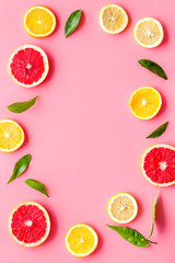 Citrus fruits - lemons, grapefruit slices - on pink background mockup, frame top-down copy space