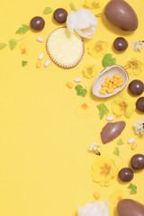 Easter yellow background with chocolatte eggs,    candy and spri