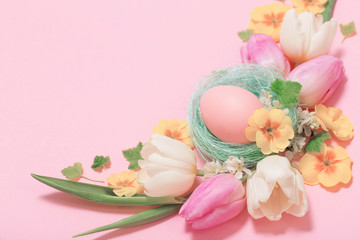 Easter eggs and spring flowers on pink background
