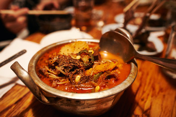 Korean Style Spicy Beef Soup with herbs in Tin Pot