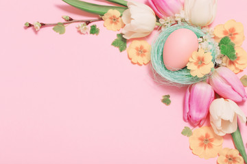 Easter eggs and spring flowers on pink background