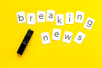 News concept. Breaking news. TV remote on yellow background top-down