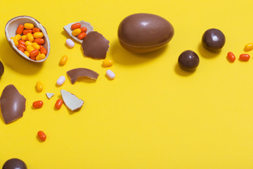 Easter yellow background with chocolatte eggs and  candy