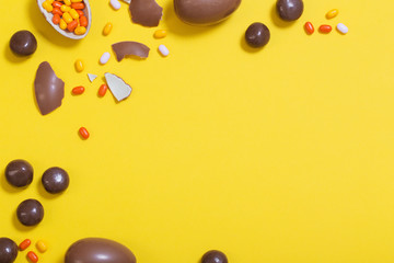 Easter yellow background with chocolatte eggs and  candy