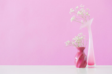  gypsophila flowers in vases on pink background